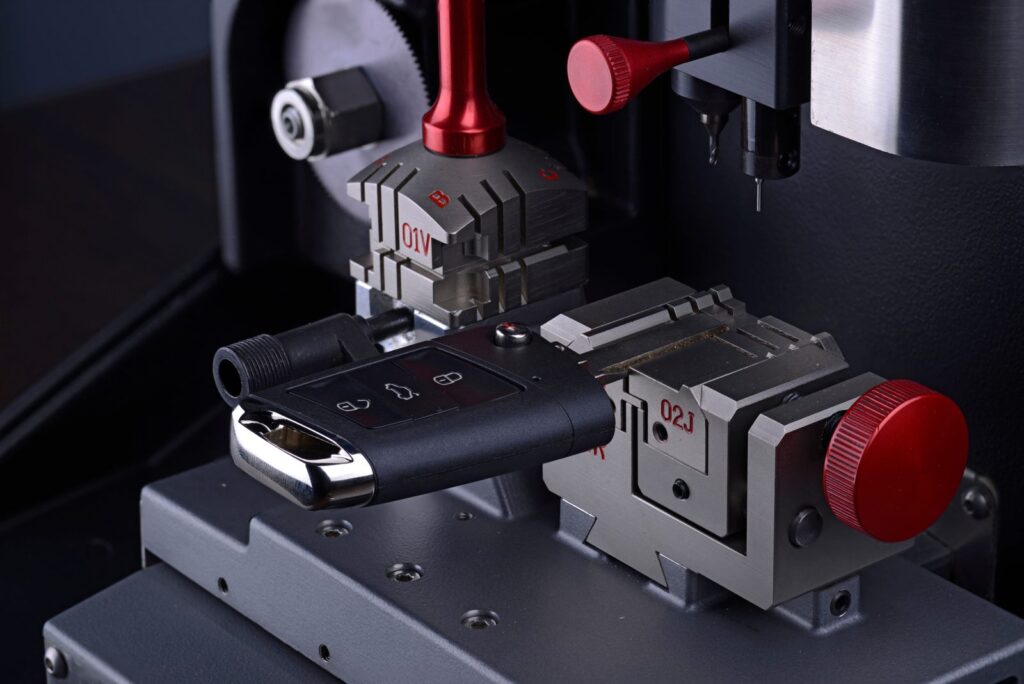 Car key fob clamped in a key cutting machine used by an automotive locksmith to cut replacement car keys