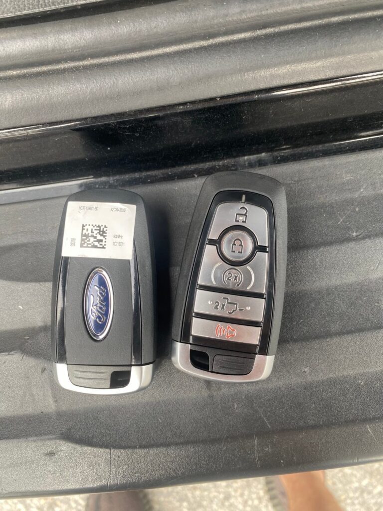 Original Ford smart key next to a new five-button Ford push-to-start key fob ready for programming
